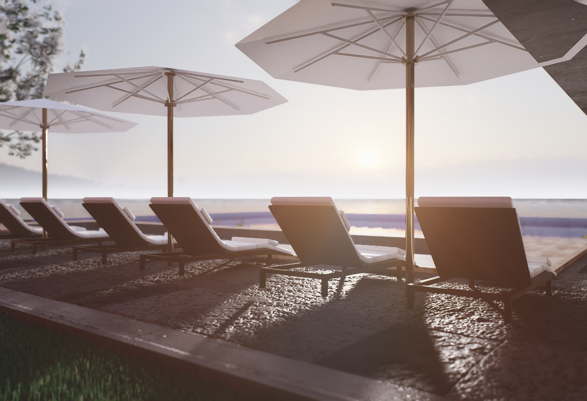 Sunset view of lounge chairs and umbrellas overlooking the water